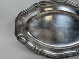 an antique silver plate on a table with a white background