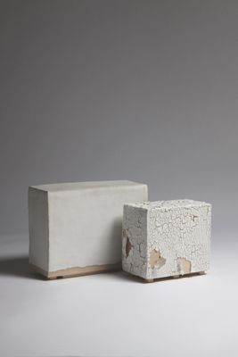 des parpaings sont empilés les uns sur les autres sur une surface blanche