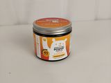 un gros plan d'une boîte de crème orange et blanche posée sur une surface blanche