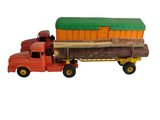 un camion miniature transportant un important chargement de grumes