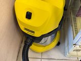 un aspirateur jaune posé dans un coin de la pièce