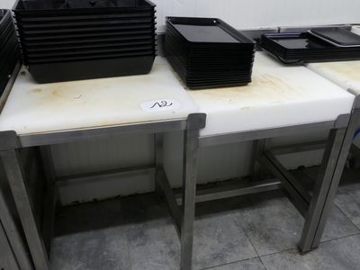 Plusieurs plateaux de nourriture sont posés sur une table dans une cuisine.