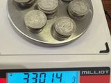 une balance numérique sur laquelle sont posées de nombreuses pièces de monnaie