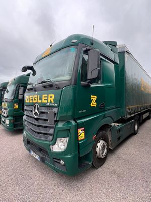 two green trucks parked next to each other in a parking lot