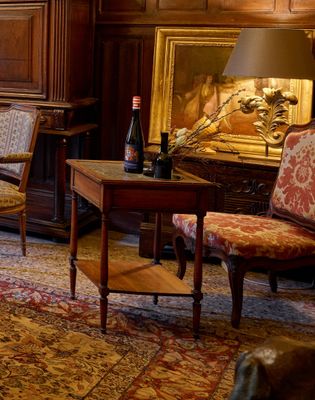 un salon avec un canapé, un fauteuil, une table et une cheminée