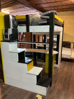 un lit superposé avec un bureau et un escalier dans la chambre