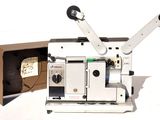 un vieux projecteur de cinéma posé sur une table à côté d'une boîte
