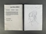 sketch of a woman ' s face in a book with a pencil