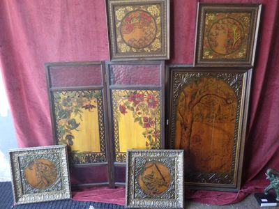 five framed pictures on the floor next to a red curtain