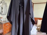 une robe noire posée sur un lit dans une chambre
