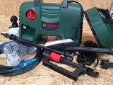 a green machine with a hose and other tools on a table