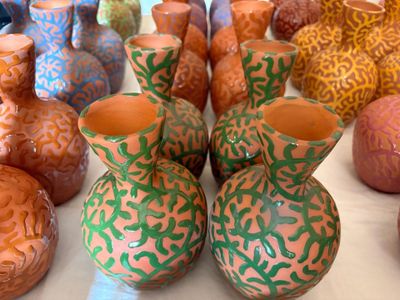 de nombreux vases de différentes couleurs posés sur une table