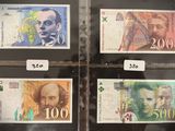 Quatre billets de banque différents sont exposés dans une vitrine.