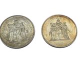 two silver coins with the image of a group of people on them