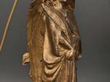 an antique bronze statue of a woman holding a flower and a staff