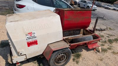 a red and white machine that is sitting in the dirt