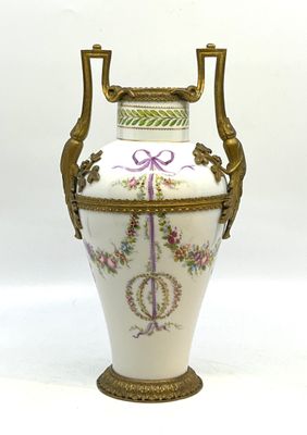 un vase blanc avec une anse dorée sur fond blanc