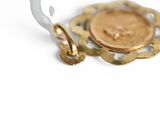 a gold coin on a hook on a white background