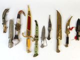 several different types of knives are lined up on a white surface