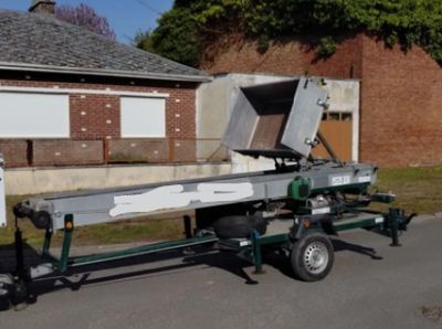 un camion attelé à une remorque sur laquelle est fixée une machine