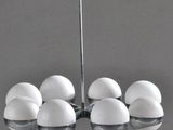 a chandelier made out of white eggs on a gray surface