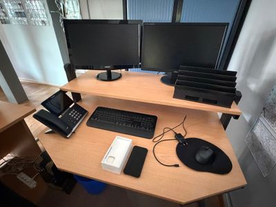 un bureau d'ordinateur sur lequel se trouvent deux écrans et un téléphone
