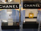 deux vitrines posées à même le sol, contenant des flacons de parfum
