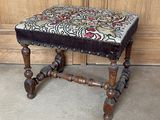 a small wooden stool with a floral design on it