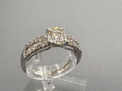 une photo d'une bague en diamant posée sur un socle transparent