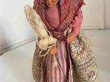a figurine of an old woman holding a bag