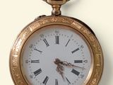 une montre de poche en or avec des chiffres romains sur le cadran