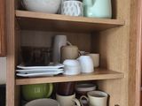 shelves filled with dishes and cups in a kitchen cupboard