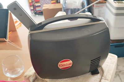 un grille-pain posé sur une table à côté d'un verre de vin