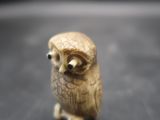 a small figurine of an owl sitting on a table