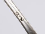 a close up of a spoon with a handle on a white surface