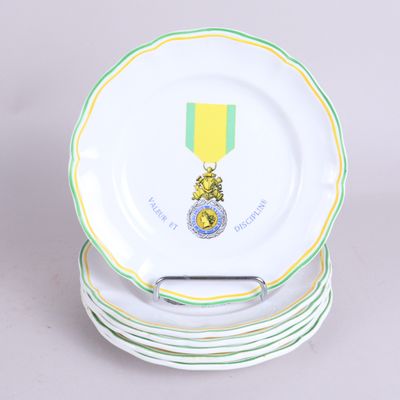 une pile d'assiettes surmontée d'une médaille