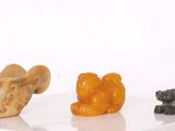 trois petites figurines d'animaux posées sur une surface blanche