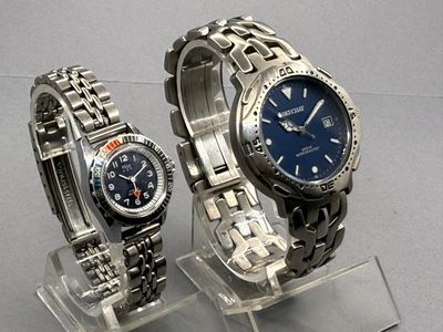 two watches that are on display on a clear stand