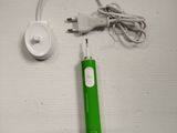 a green toothbrush and a charger sitting on a table