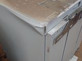 a white refrigerator sitting on a pallet in a room
