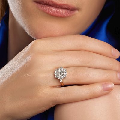 une femme qui porte une bague en diamant au doigt