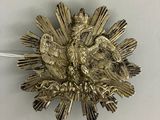 une broche en argent surmontée d'un oiseau