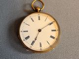 une montre de poche en or avec des chiffres romains sur le cadran