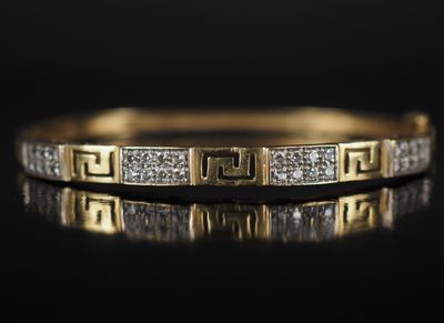 gros plan d'une bague en or et diamants sur une surface noire