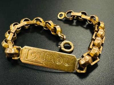 a close up of a gold bracelet on a black surface