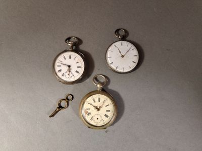 trois types différents de montres de poche posées sur une table