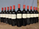 six bottles of red wine are lined up on a wooden table