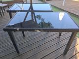 a glass table that is on a wooden deck