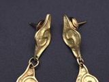 pair of gold plated earrings on a black surface