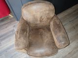 a brown chair that is sitting on a hard wood floor